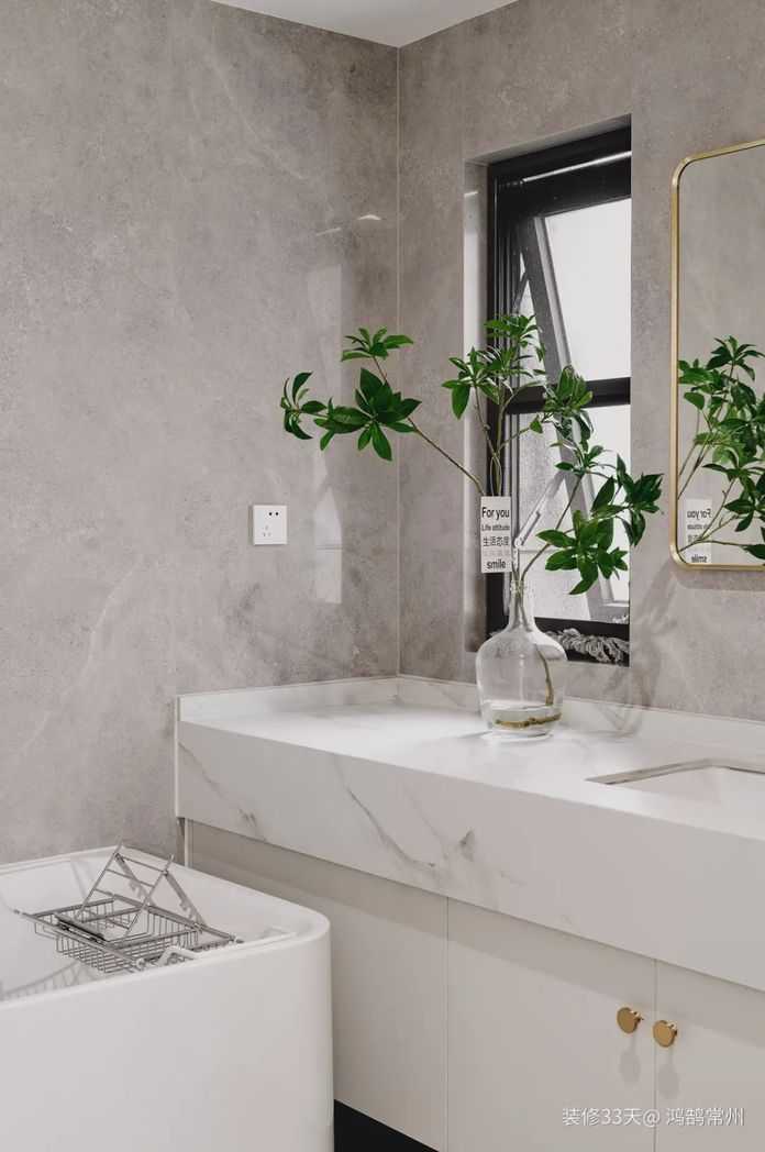 主衛，石色瓷磚搭配白色衛浴，金邊牆鏡提升精緻度，選擇浴缸取代淋浴房